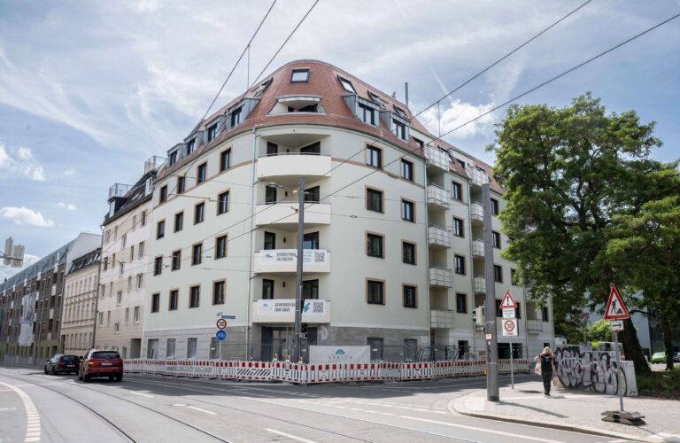 Außenansicht des Parkblicks mit fertiggestellter heller Fassade, Balkonen und rotem Dach