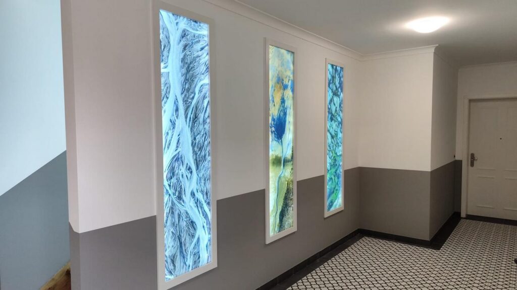 beleuchtete Wandbilder im Treppenhaus Torhaus