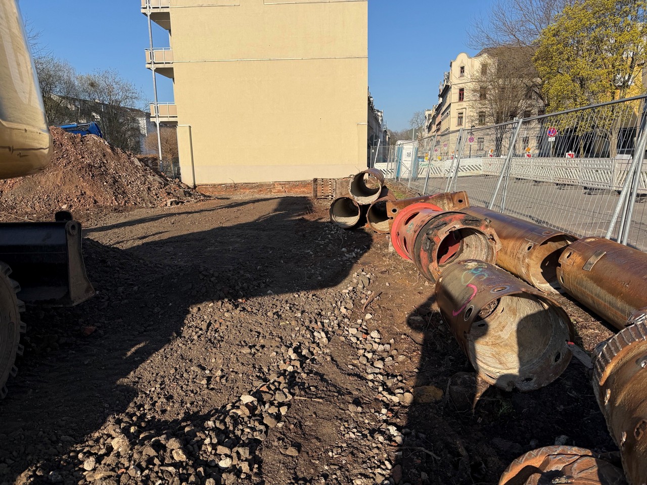 Baustelle mit Aushubarbeiten und Verbaurohren neben bestehendem Gebäude in innerstädtischer Lage