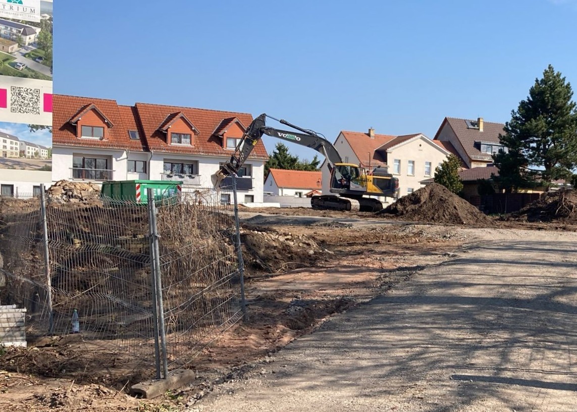 Bagger bei Erdarbeiten auf Baustelle in Leipzig-Portitz mit Wohnhäusern im Hintergrund