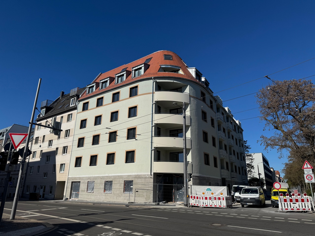 Fertiggestellte Fassade des Gebäudes Parkblick mit hellem Außenputz, Balkonen und rotem Dach